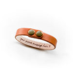 Tan leather bracelet with two snaps and a hidden engraving on the inside that says 'your secret message here (heart)'